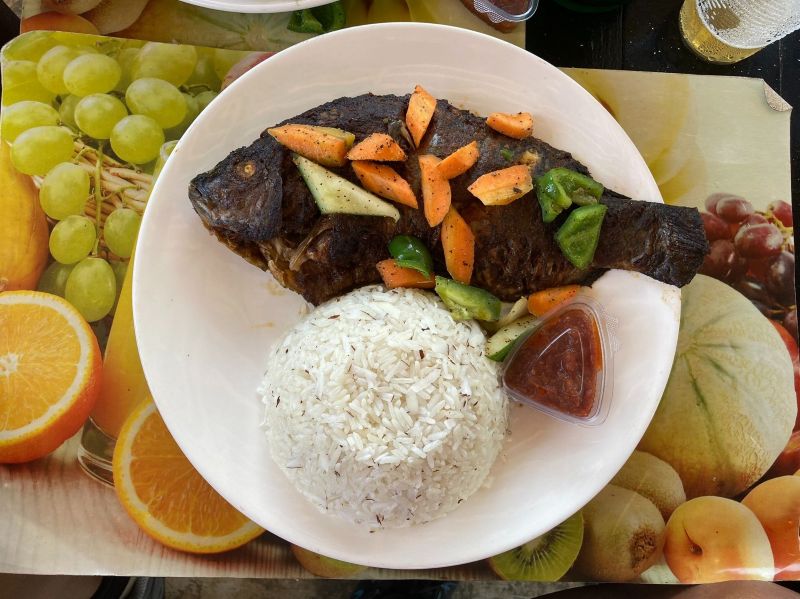 Savoring the rich flavors of Ghana, no visit is complete without a plate rice and fresh grilled tilapia.